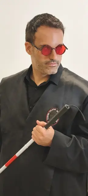 Justicia Ciega con gafas rojas y bastón blanco