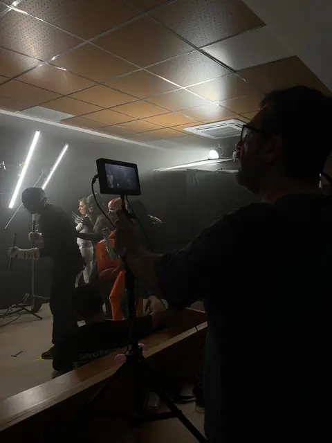 El plató a oscuras con luces y un monitor